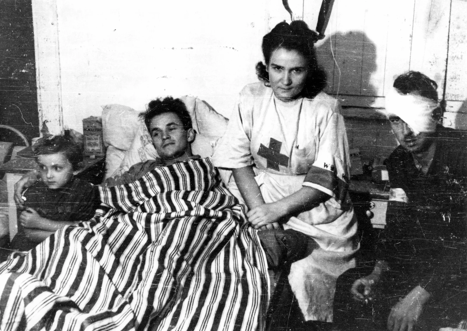 Sanitariuszka Janina Stęczniewska z córką Hanią oraz ranny powstaniec Edmund Michniewski w szpitalu kompanii Koszta, sierpień 1944